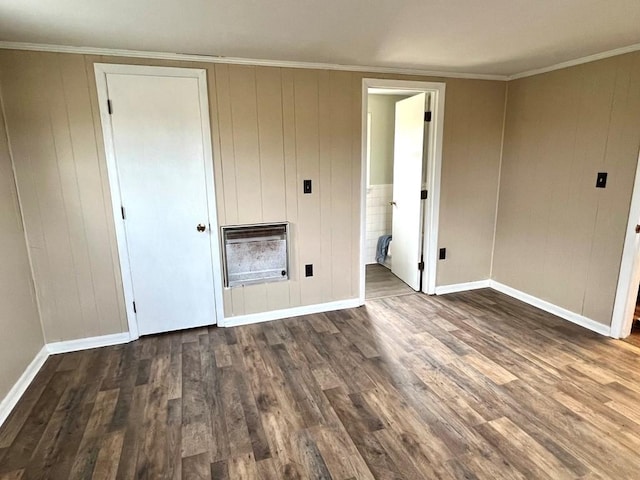 unfurnished bedroom with ensuite bathroom, crown molding, dark wood-type flooring, and heating unit