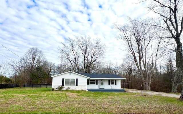 ranch-style house featuring covered porch and a front yard