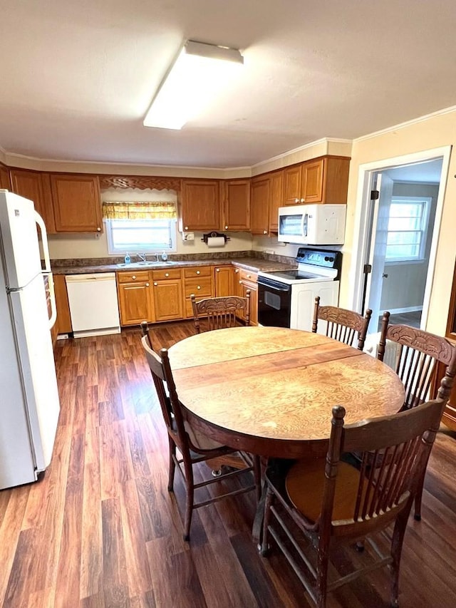 kitchen with dark hardwood / wood-style flooring, white appliances, crown molding, and sink