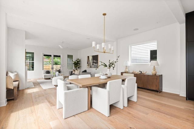 dining area with ceiling fan with notable chandelier and light wood-type flooring