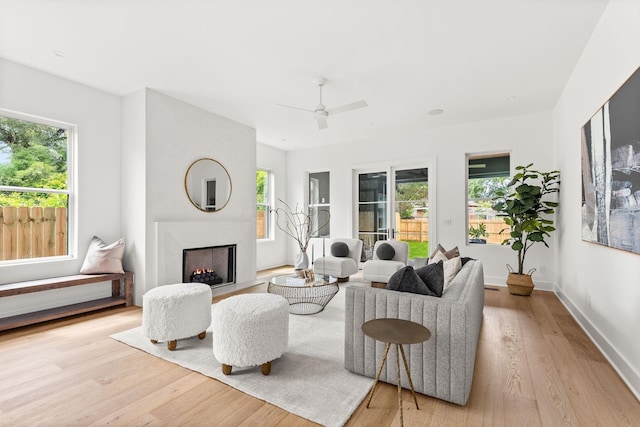 living room featuring ceiling fan, light hardwood / wood-style floors, and plenty of natural light