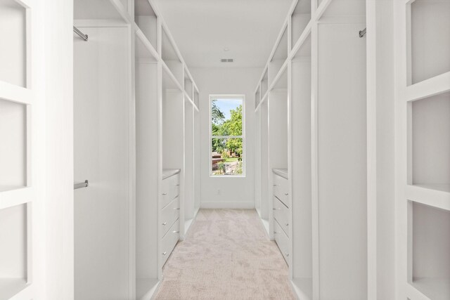 walk in closet featuring light colored carpet