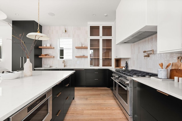 kitchen with white cabinetry, hanging light fixtures, double oven range, light hardwood / wood-style floors, and custom range hood