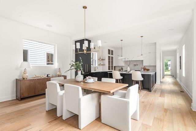 dining area with a chandelier and light hardwood / wood-style floors