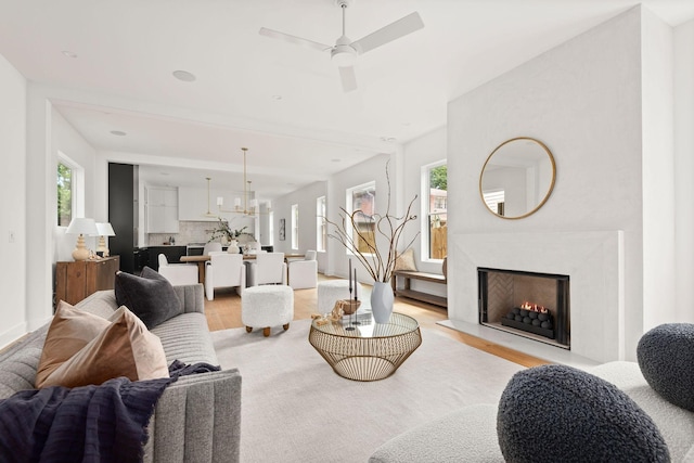 living room with ceiling fan and light wood-type flooring