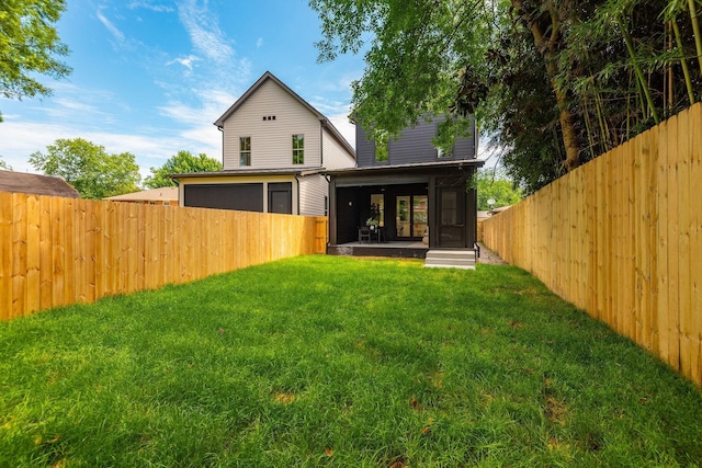 rear view of house featuring a lawn and a sunroom