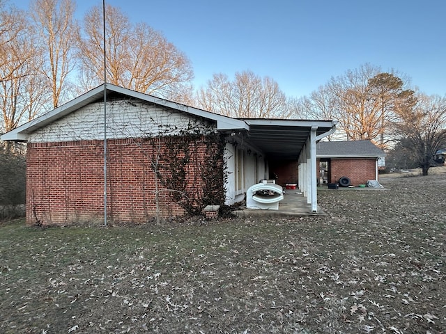 view of side of property with a carport and a yard