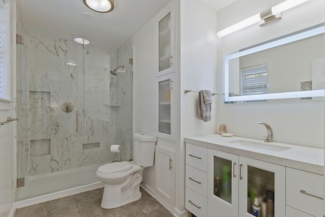 bathroom featuring a shower with door, vanity, and toilet