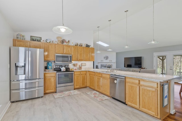 kitchen featuring sink, hanging light fixtures, stainless steel appliances, kitchen peninsula, and light wood-type flooring