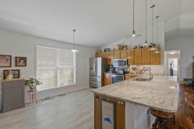 kitchen featuring pendant lighting, stainless steel appliances, vaulted ceiling, and sink