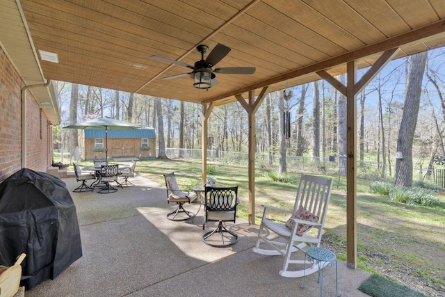 view of patio / terrace with ceiling fan, an outdoor structure, and a grill