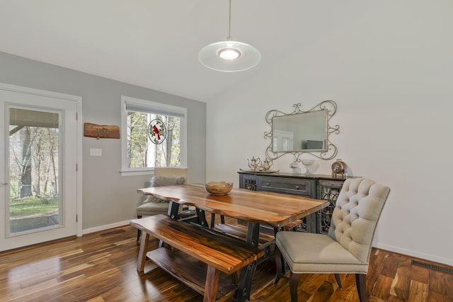 dining room featuring dark hardwood / wood-style flooring and vaulted ceiling