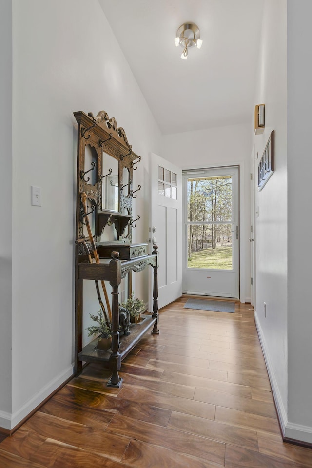 doorway to outside with hardwood / wood-style floors and vaulted ceiling