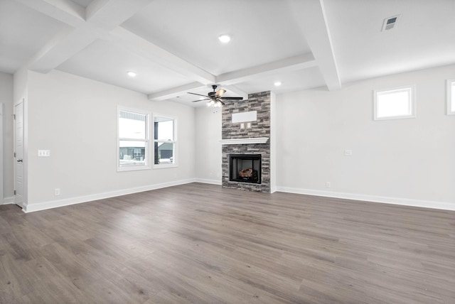 unfurnished living room with dark hardwood / wood-style floors, a fireplace, coffered ceiling, ceiling fan, and beam ceiling