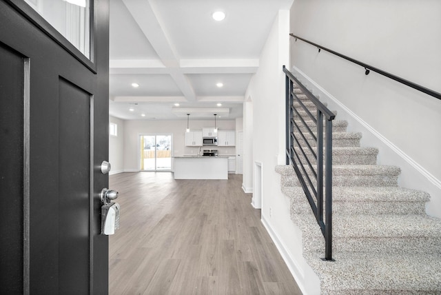 foyer with coffered ceiling, beam ceiling, and light hardwood / wood-style floors