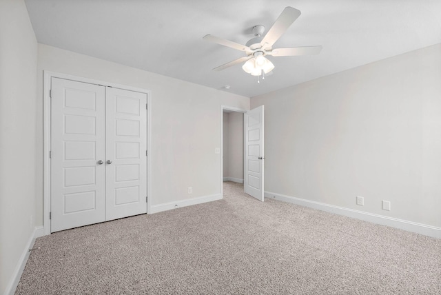 unfurnished bedroom featuring ceiling fan, light colored carpet, and a closet