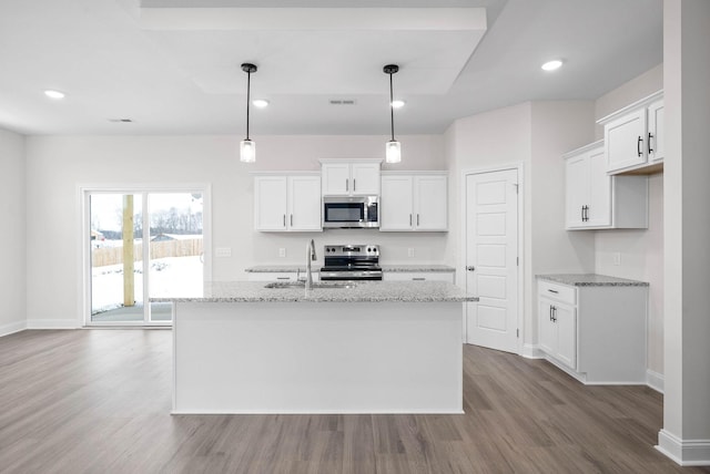 kitchen with stainless steel appliances, light stone countertops, sink, and white cabinets