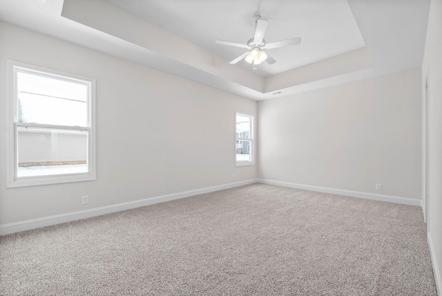 unfurnished room featuring carpet floors, ceiling fan, and a tray ceiling