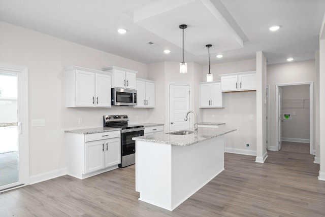 kitchen featuring white cabinetry, sink, a kitchen island with sink, light stone counters, and stainless steel appliances