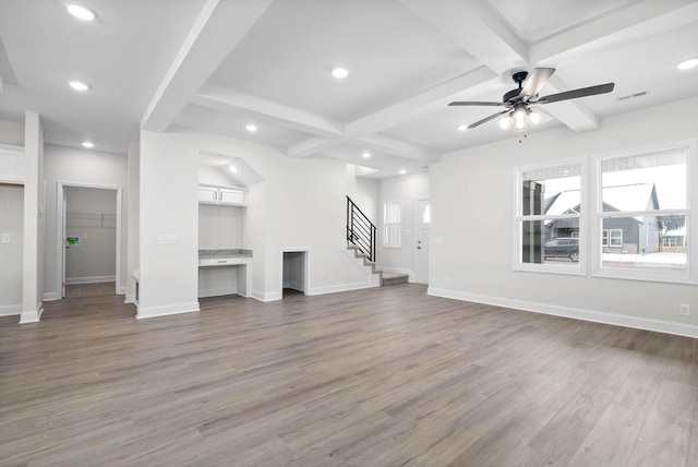 unfurnished living room featuring beamed ceiling, ceiling fan, coffered ceiling, and hardwood / wood-style floors