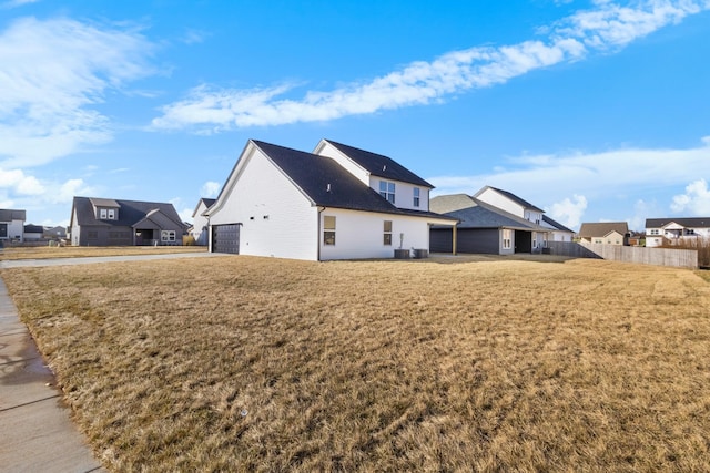 rear view of house featuring a garage and a lawn