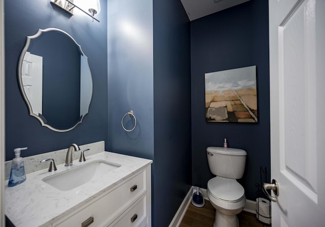 bathroom with wood-type flooring, vanity, and toilet