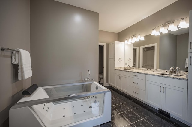 bathroom with vanity, a tub to relax in, and toilet