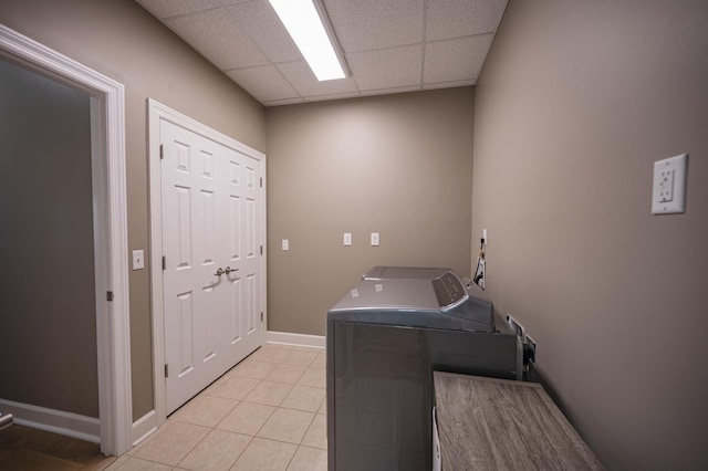 laundry area with washing machine and dryer and light tile patterned floors