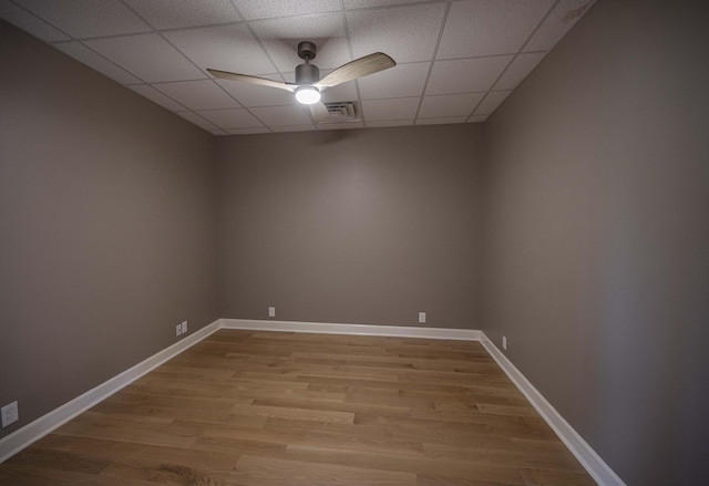 unfurnished room with a paneled ceiling, ceiling fan, and hardwood / wood-style flooring