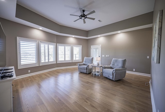 living area with ceiling fan and hardwood / wood-style floors