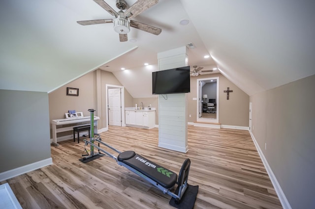 exercise room featuring light hardwood / wood-style flooring, ceiling fan, and lofted ceiling