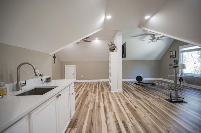 interior space featuring ceiling fan, sink, and light wood-type flooring