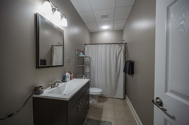 bathroom featuring a paneled ceiling, vanity, a shower with shower curtain, tile patterned flooring, and toilet