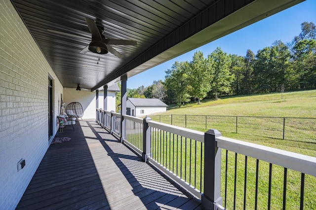 wooden deck with ceiling fan and a yard