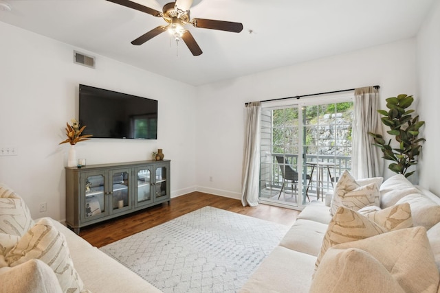 living room featuring dark hardwood / wood-style flooring and ceiling fan