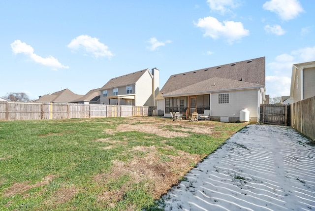 back of property featuring a lawn, a sunroom, and a patio