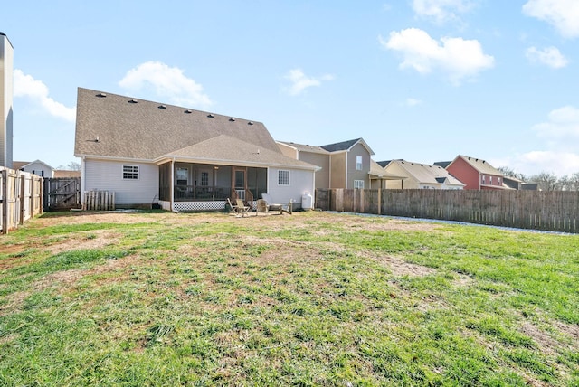 rear view of house with a sunroom and a yard