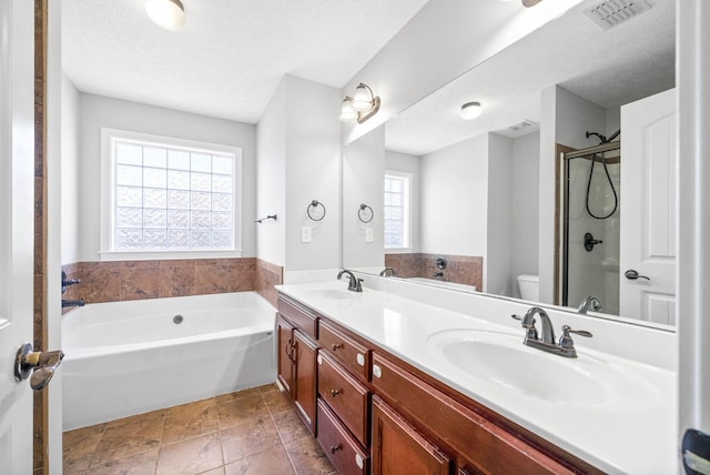 full bathroom with vanity, a healthy amount of sunlight, a textured ceiling, and toilet