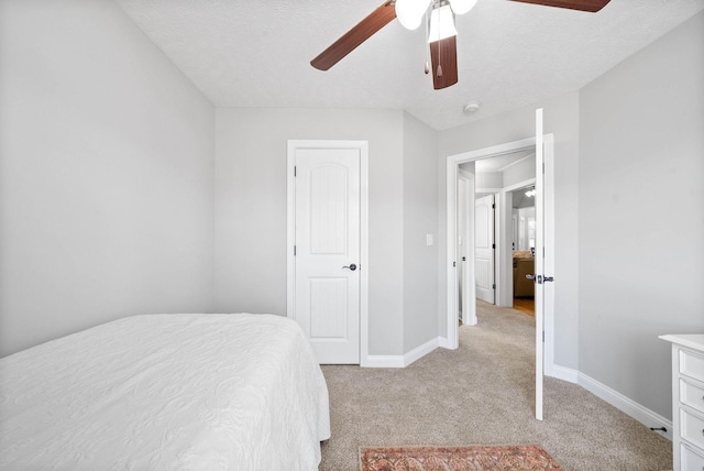 bedroom featuring ceiling fan, light carpet, and a textured ceiling