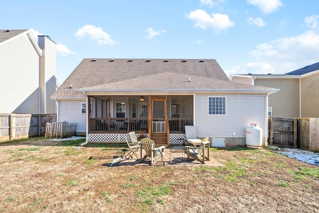 back of property with a sunroom, a patio, and a lawn