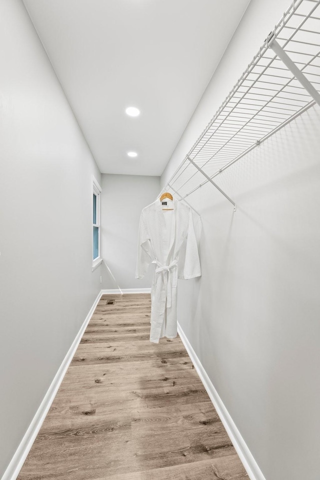 hallway featuring wood finished floors and baseboards