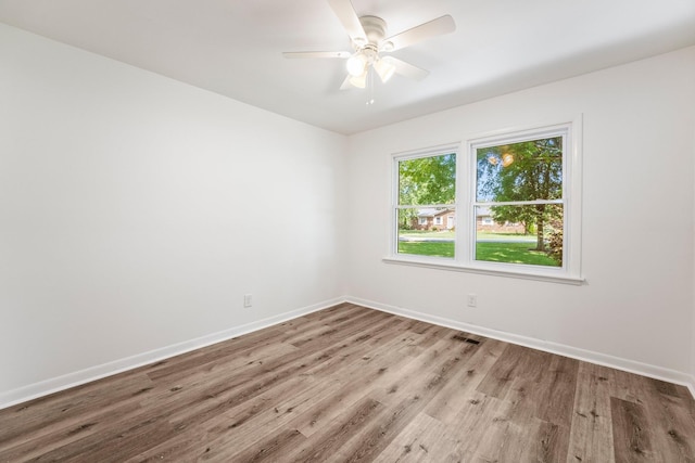 spare room with light wood-style floors, visible vents, baseboards, and a ceiling fan