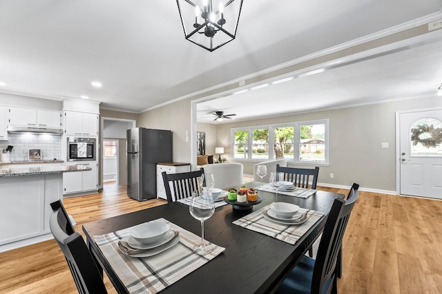 dining room with light wood-type flooring, baseboards, ornamental molding, and a ceiling fan