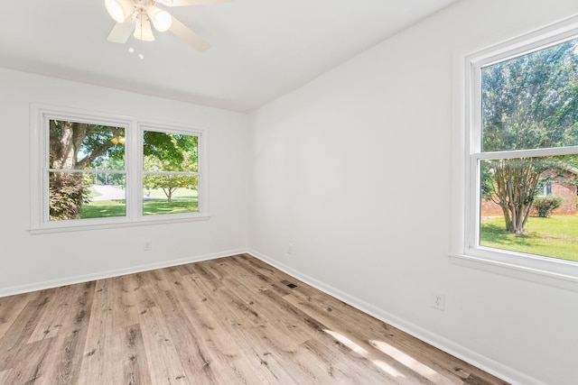 empty room featuring light wood-type flooring, a healthy amount of sunlight, and baseboards