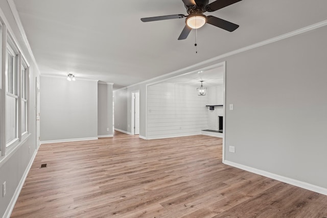 unfurnished living room with visible vents, baseboards, ceiling fan, ornamental molding, and light wood-style floors