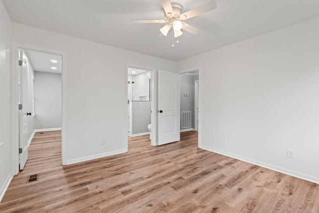 unfurnished bedroom featuring light wood-style floors, baseboards, a spacious closet, and visible vents