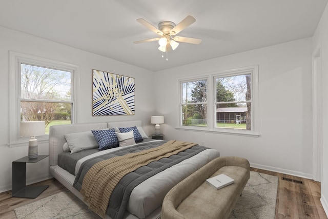 bedroom featuring light wood-type flooring, multiple windows, and visible vents