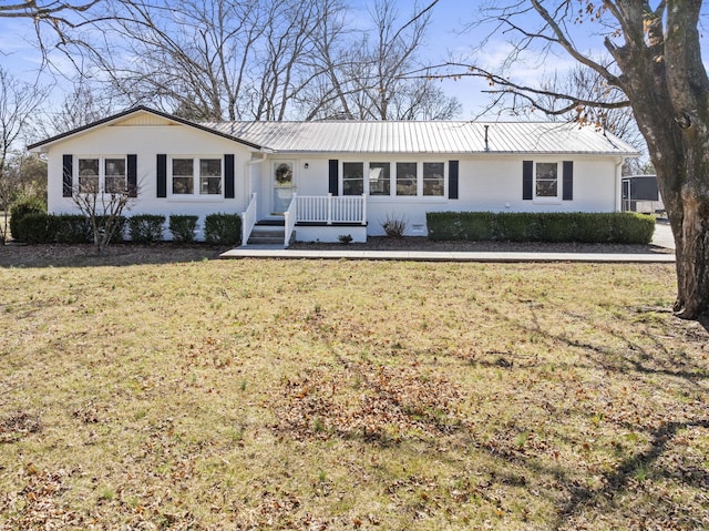 single story home featuring a front yard, brick siding, and metal roof