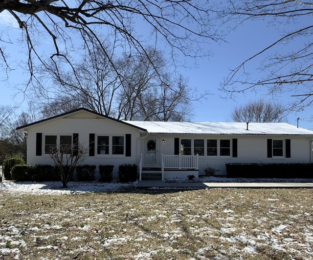 ranch-style house featuring covered porch and metal roof