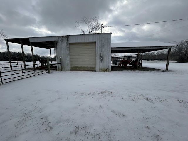 snow covered structure featuring a garage